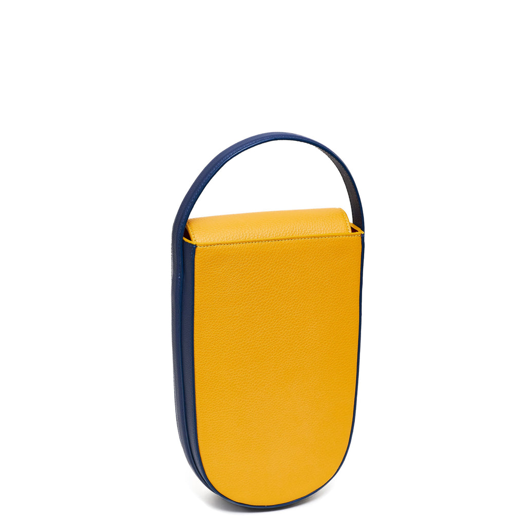 A colorful blue and yellow mini leather tote handbag. The handbag has an elongated rounded shape and a blue adjustable top handle. The hardware is gunmetal. This is the front view of the Tomoli Fitini bag in Shady Maize.