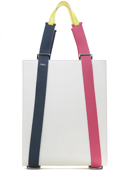 A product photo of a color-blocked off-white leather tote handbag. The tote has a structured rectangular shape and flat handles. This is the Tomoli Kora tote in eclectic ivory aria leather. This bag can be used as a work bag or an everyday bag.