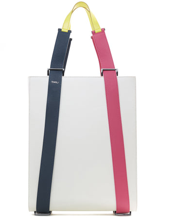 A product photo of a color-blocked off-white leather tote handbag. The tote has a structured rectangular shape and flat handles. This is the Tomoli Kora tote in eclectic ivory aria leather. This bag can be used as a work bag or an everyday bag.
