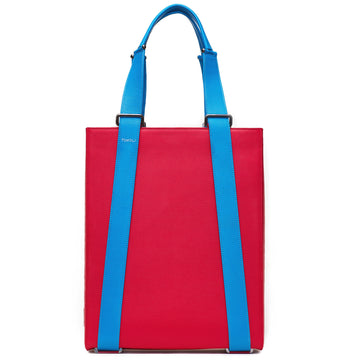 The product photo of a red leather tote bag. The tote bag has a structured rectangular briefcase shape and is color-blocked with blue leather straps. This is the front view of the Tomoli Kora large convertible leather tote in sky red. The bag can fit a laptop and can be styled for work or to elevate casual outfits.