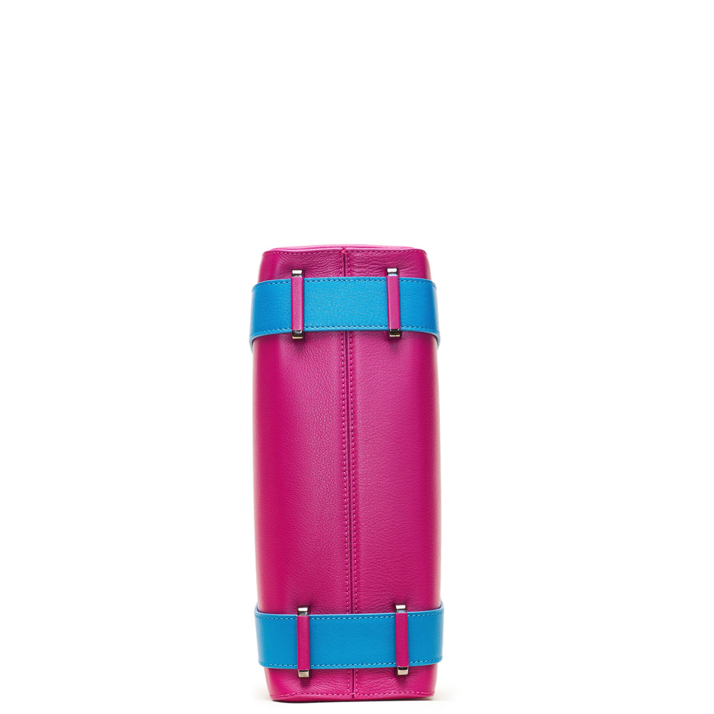 A product photo showing the bottom view of a pink leather tote. The bottom shows a center seam and color-blocked blue straps. This is the Tomoli Kora large convertible leather tote in Sky Fuchsia.