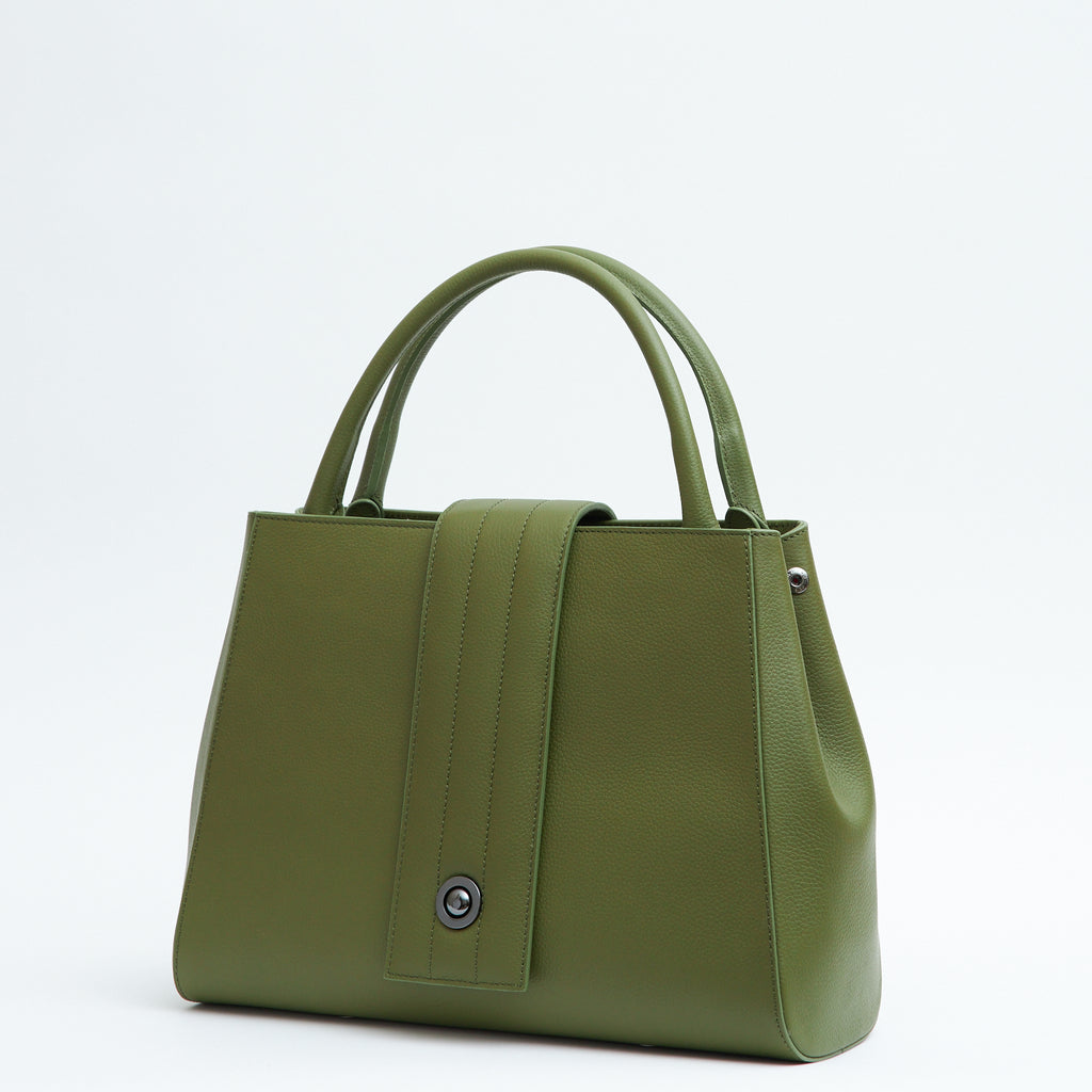 The product photo of an olive green leather handbag. The handbag has a classic trapeze shape with a straight quilted flap in the middle and top handles. This is the side view of the Tomoli Briffani Lean interchangeable tote handbag in Olive Green. This bag can be used as an everyday bag, a work tote, or even an oversized clutch.