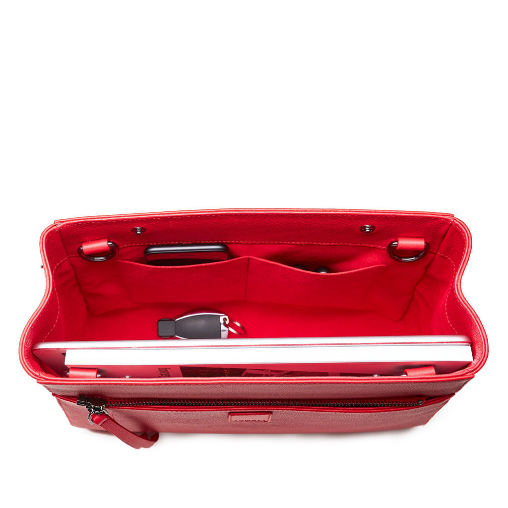 The product photo of a fashion handbag showing the interior of a red leather bag. The bag has a bright red lining made of alcantara microsuede material. This is the interior view of the Tomoli Briffani Lean interchangeable leather tote handbag. This bag fits a laptop and a large iPad Pro tablet.