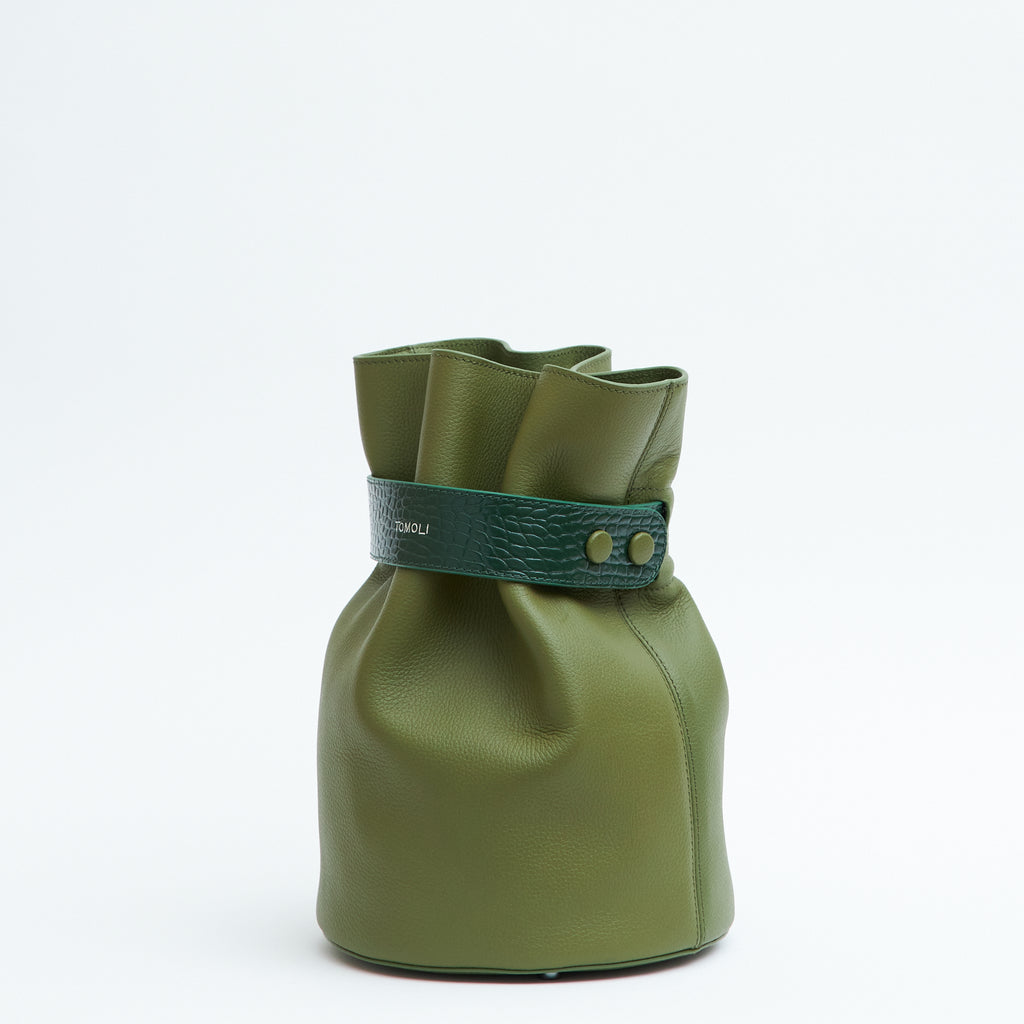 A product photo showing the side view of an olive green leather bucket bag. The bag has a bold belt cinch in croc-embossed leather. The belt has an adjustable snap closure on the side.